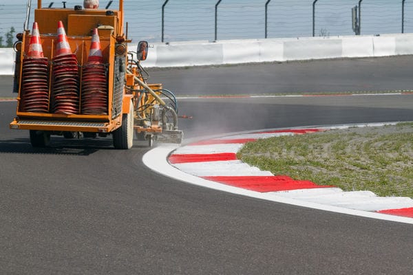 Markierungsfahrzeug bringt frische Markierung auf Rennstrecke auf.